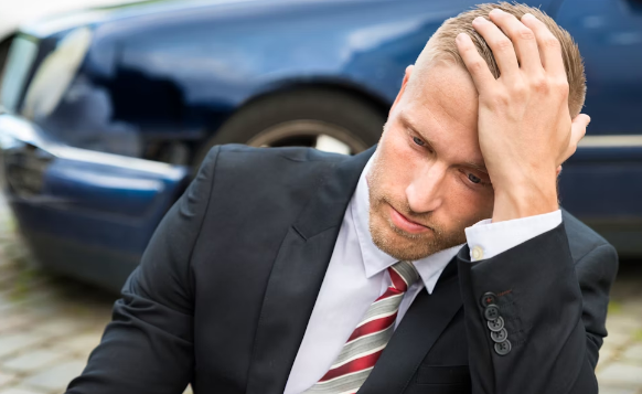 Man in tie holding head in hand