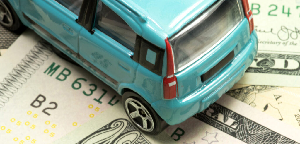 Photo of car over dollar bill